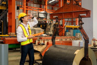 Makine operatörü çelik üretim makinelerini ustalıkla çalıştırıyor, metal fabrikasındaki ağır inşaat mühendisliği malzemeleri için silindir rulo çelik üretiyor. Örnek gösteriliyor