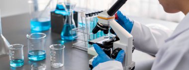 Bilim adamları yeni bir aşı ilacı ya da antibiyotik geliştirmek için mikroskop kullanarak tıbbi laboratuarda kimyasal deney yapıyorlar. Biyoteknoloji laboratuvarı ve tıp araştırma konsepti. Neoterik