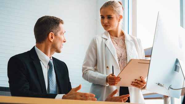 Двое бизнесменов обсуждают стратегию проекта в конференц-зале. Бизнесмен обсуждает проектное планирование с коллегой на современном рабочем месте во время беседы и консультирования по финансовому отчету. Дживи