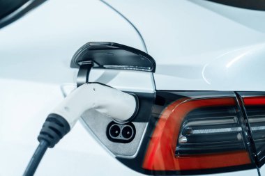 Alış veriş merkezinin otoparkında EV elektrikli araba şarjı şehir merkezindeki sürdürülebilirlik yaşam tarzını yeşil, temiz, yeniden şarj edilebilir elektrikli araç iç organları ile gösteriyor.