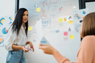 Kafkasyalı genç bir yönetici, iş sorularını güvenle cevaplarken zihin haritası, grafik kullanarak pazarlama stratejisi sunuyor. Takım çalışması, beyin fırtınası, tartışma konsepti. Tertemiz..