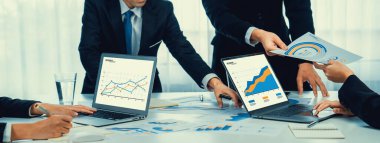 Grup toplantısındaki iş adamları resmi kıyafet paylaşımı fikrine sahipler. Şirketin yaratıcı çalışma alanındaki kar raporunu tartışıyorlar. Grup toplantısı masasında yakın çekim yapmak için. Konuşma .