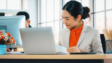 Modern ofis odasındaki masada çalışan iş adamları mali veri raporlarını incelerken. Jivy