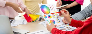 Profesyonel iç mimarın kırpılmış bir görüntüsü, renk örnekleri ve renk paleti belgeleriyle karşılaştırarak iş arkadaşlarıyla renk materyalini tartışıyor. Yaratıcı tasarım konsepti. Değiştirilmiş.