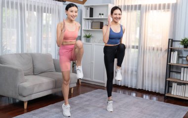 Enerjik ve güçlü atletik Asyalı kadın ve evinde koşan antrenman arkadaşı. Formda fiziğin takibi ve ev çalışması ve eğitimle sağlıklı yaşam tarzına bağlılık. Kuvvetli