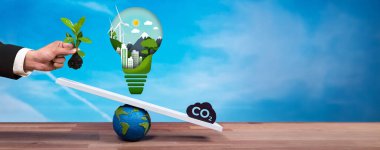 İş adamı ampulü CO2 emisyon ikonu ile ölçekte dengeleyerek, temiz enerji teknolojisiyle karbon azaltımına ilişkin ESG kararlılığını ve çevresel muhafazakar fikri göstermektedir. Panorama Güvenliği