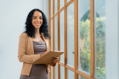 Klinikteki psikolog kadın. Profesyonel portresi. Dostane gülümsemesiyle hastayı psikoloğa davet ediyor. Deneyimli ve kendinden emin psikolog çok önemli bir uzmandır.