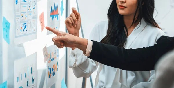 Young manager with suit pointing at whiteboard brainstorming business idea presenting data analysis to his female colleague. Finding out of solution solving the problem. closeup. Intellectual.