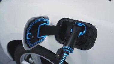 Fütürist EV şarj cihazıyla elektrikli araba şarj istasyonundan şarj oluyor. EV arabaların son teknoloji gelişimi ve sürdürülebilir enerji için akıllı ev yenilenebilir enerji altyapısı. İnceleyin