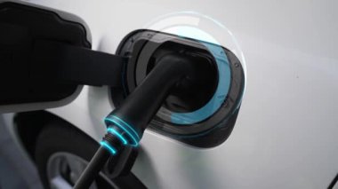 Elektrikli araba, gelecekteki ev şarj istasyonunda akıllı dijital EV batarya durumu hologramıyla şarj oluyor. EV arabasının teknolojik gelişimi ve sürdürülebilir gelecek için ev enerjisi altyapısı. İncelenme