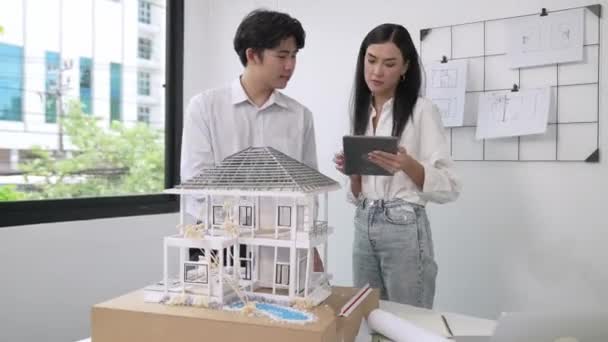 코카서스 프로젝트 매니저 아시아 엔지니어 청사진 장비와 테이블에 모델을 태블릿을 — 비디오
