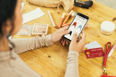 İnternet pazarından alışveriş yapan kadın modern yaşam tarzı için satış malzemeleri arıyor ve önemli siber güvenlik yazılımları tarafından korunan cüzdandan çevrimiçi ödeme için kredi kartı kullanıyor