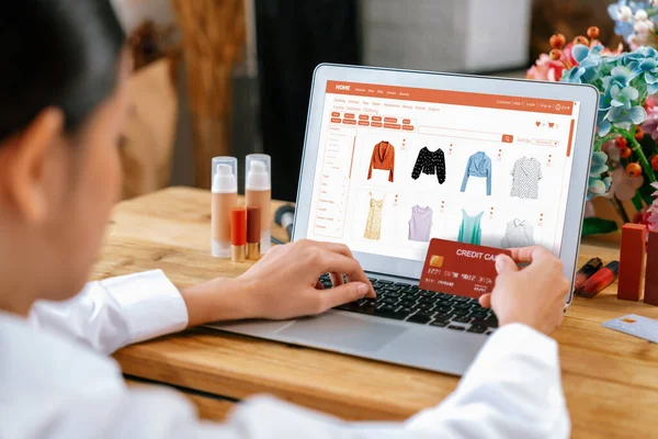 Woman shopping online on internet marketplace browsing for sale items for modern lifestyle and use credit card for online payment from wallet protected by uttermost cyber security software