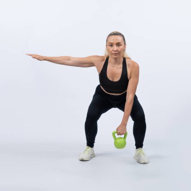 Vücut uzunluğu tam, atletik ve sportif yaşlı kadın izole edilmiş arka planda vücut çalışması için kettlebell ile hiç bir şey yapmıyor. Emeklilikten sonra sağlıklı, aktif bir fiziğe ve vücut bakımına sahip. Etki