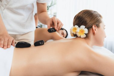 Lüks tatil köyündeki kaplıca salonunda sıcak taş masajı. Gündüz dinginliği ortam, mutlu çift müşterileri bazalt taşı masajının keyfini çıkarıyor. Rahatlatıcı bir sıcaklıkla vücudun üzerinde süzülüyorlar. Sessiz.