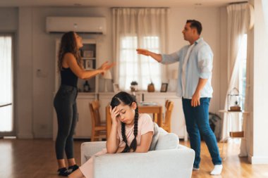 Sinirli ve mutsuz genç bir kız oturma odasında ebeveyninin tartışması yüzünden gerginliğin ortasında kanepede oturuyor. Sağlıksız ev hayatı ve travmatik çocukluk depresyona dönüşür.