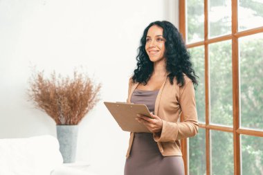 Klinikteki psikolog kadın. Profesyonel portresi. Dostane gülümsemesiyle hastayı psikoloğa davet ediyor. Deneyimli ve kendinden emin psikolog çok önemli bir uzmandır.