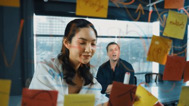 Genç kendine güvenen iş kadını projeyi uzman yatırımcıya sundu. Profesyonel proje yöneticisi başlangıç projesini açıklamak için yapışkan notlar kullanır, beyin fırtınası fikirlerini yatırımcıya paylaşır. Yönlendirici.