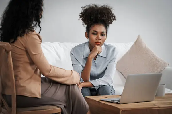 Sad PTSD woman patient in crucial therapy for mental health with psychologist, depression or grief after life failure. Frustrated trauma young woman talking to a psychologist about emotion in clinic