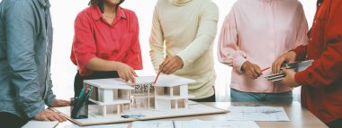 Profesyonel iç mimari ekibinin ev malzemelerini tartışırken akıllı mühendis ekibinin ev inşaatı hakkında beyin fırtınası yaptığı bir görüntü. Yaratıcı çalışma ve takım çalışması konsepti. Değiştirilmiş