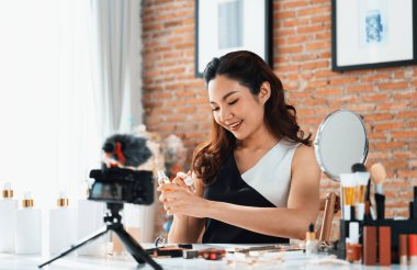 Asyalı Kadın Etkilenen Vlog 'ta canlı yayın yapan videolar sosyal medya ya da blog' un çoğunu oluşturuyor. Kozmetik stüdyosu ışıklandırmalı mutlu genç kız çevrimiçi pazarlama oturumu yayını için.