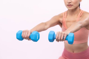 Güçlü enerjik kadın halter kaldırma egzersizi yapıyor izole arka planda. Genç atletik Asyalı kadın dayanıklılığı ve dayanıklılık eğitimi rutin vücut egzersizi..