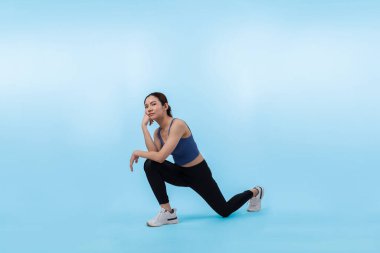 Spor giyimli çekici Asyalı kadın spor egzersizlerinden önce esneme hareketleri yapıyor. Stüdyo çekimlerinde ısınan atletik bir kadınla sağlıklı vücut bakımı egzersizi. Kuvvetli