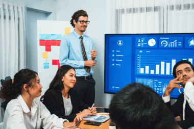 İş adamı, finansal rapor veri analizi veya pazar eğilimi gösterisiyle iş sunumunu şirketin gelecekteki yönetiminde stratejik planlama için büyük bir TV ekranında sundu. Habiliment