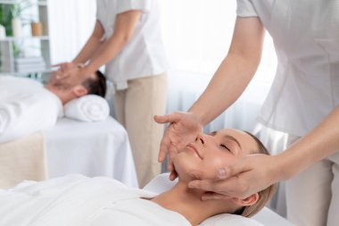 Kafkasyalı çift stres önleyici kafa masajının keyfini çıkarıyor ve lüks otellerde ya da otel spa salonlarında gündüz kaplıcalarında yüz güzelliği eğlencelerini şımartıyor. Sessiz.