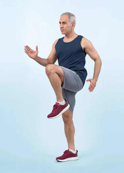 Active and fit physique senior man in sportswear portrait in running posture isolated background. Healthy lifelong senior people with fitness healthy and sporty body care lifestyle concept. Clout