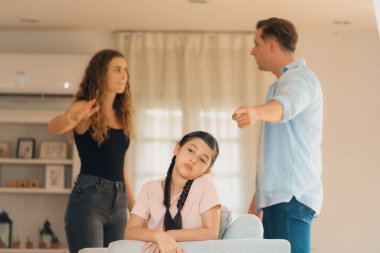 Sinirli ve mutsuz genç bir kız oturma odasında ebeveyninin tartışması yüzünden gerginliğin ortasında kanepede oturuyor. Sağlıksız ev hayatı ve travmatik çocukluk depresyona dönüşür.