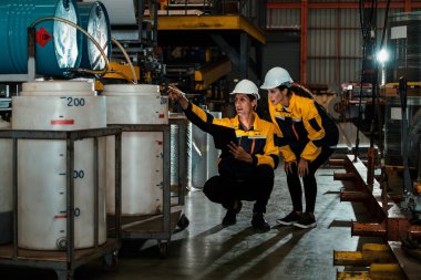 İki fabrika işçisi veya mühendis, kimya fabrikası, kimya fabrikası işyeri ve endüstriyel meslek konseptinde makine veya prosedür üzerinde profesyonel teftiş yürütüyor. Örnek gösteriliyor