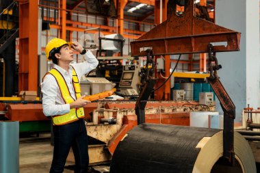 Makine operatörü çelik üretim makinelerini ustalıkla çalıştırıyor, metal fabrikasındaki ağır inşaat mühendisliği malzemeleri için silindir rulo çelik üretiyor. Örnek gösteriliyor