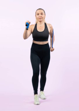 Vücut uzunluğu tam, atletik ve sportif yaşlı kadın izole edilmiş arka planda halat egzersizi yapıyor. Sağlıklı aktif fizik ve vücut bakımı son sınıf öğrencileri. Etki