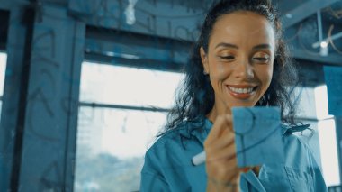 Genç İspanyol çalışanlar renkli yapışkan notlar yazıyorlar. Akıllı iş kadını pazarlama fikrini, beyin fırtınası stratejisini, iş planını paylaşıyor. Proje yöneticisi zihin haritası çiziyor. - Yakın çekim. Yönlendirici.