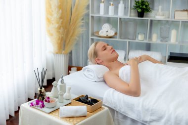 Kafkasyalı kadın müşteri stres önleyici spa masajının keyfini çıkarıyor ve lüks otel ya da oteldeki gündüz açık ortam güzellik salonunda güzellik teniyle eğleniyor. Sessiz.