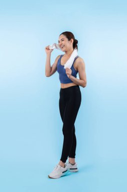 Spor giyim portresindeki tüm vücut Asyalı kadın gülümsüyor ve neşeli bir jest yapıyor. Çekici bir kızla egzersiz yapmak sağlıklı yaşam tarzını sürdürmeye yöneliktir. İzole edilmiş arka plan Vigorous