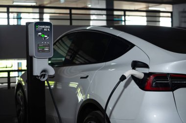 Alış veriş merkezinin otoparkında EV elektrikli araba şarjı şehir merkezindeki sürdürülebilirlik yaşam tarzını yeşil, temiz, yeniden şarj edilebilir elektrikli araç iç organları ile gösteriyor.
