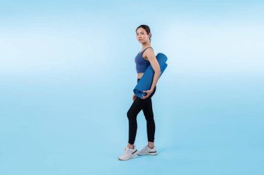 Spor kıyafetleriyle spor minderiyle genç ve çekici Asyalı kadın portresi. Sağlıklı egzersiz ve rutin yaşam tarzı konsepti. Stüdyo çekimi izole edildi. Kuvvetli