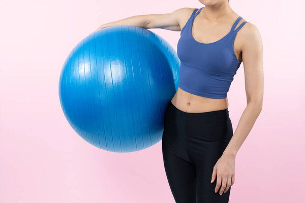 Молодая привлекательная азиатская женщина портрет в спортивной одежде с фитнес мяч таргетинг на мышцы живота для эффективной энергичной повседневной тренировки. Студийные съемки и изолированный фон. Бдительность