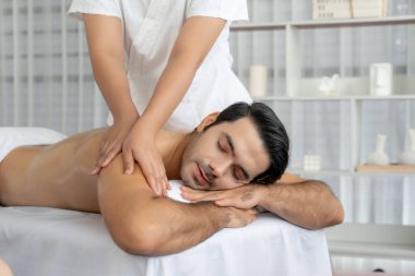 Kafkas erkek müşteri stres önleyici spa masajının keyfini çıkarıyor ve lüks otel veya oteldeki gündüz açık hava ortamında güzellik derisi eğlencesi ile şımartıyor. Sessiz.