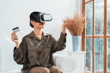 Sanal gerçeklik gözlüğü kullanan genç bir kadın online alışveriş deneyimi için evde. Sanal gerçeklik VR yeniliği dijital eğlence yaşam tarzı için optimize edildi.