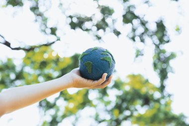 Dünya gezegenini ESG ilkesi ve çevre dostu enerjisiyle daha parlak bir gelecek için Dünya günü olarak el ele tutuşan genç çocuklar. Döngü