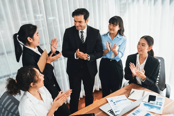 Group of happy businesspeople in celebratory gesture and successful efficient teamwork. Diverse race office worker celebrate after made progress on marketing planning in corporate office. Meticulous