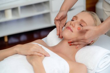 Kafkasyalı kadın stres önleyici kafa masajından ve lüks tatil beldesi ya da otel spa salonundaki modern ışık ortamında yüz güzelliği eğlencelerini şımartmaktan hoşlanıyor. Sessiz.