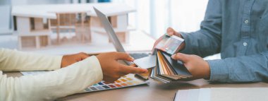 Mimar takımı iç tasarım hakkında renk paleti kullanarak tartışır. Profesyonel iç mimar, toplantı masasına yerleştirilmiş ev modeli olan müşteriye uygun rengi sunar. Değiştirilmiş.