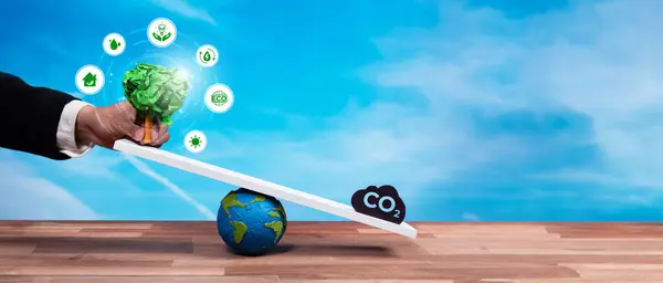 Businessman balance tree sprout on scale with CO2 emission icon, demonstrate ESG or environment social governance commitment to carbon reduction through clean energy technology. Panorama Reliance