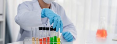 Laboratuvar araştırmacısı laboratuvar tüpünde renkli kimyasal sıvı kullanarak yeni ilaç ya da tedavi geliştirir. Laboratuvar ekipmanları ile bilimsel uzmanlık ile sağlık hizmetlerinin teknolojik gelişimi. Panorama Katı