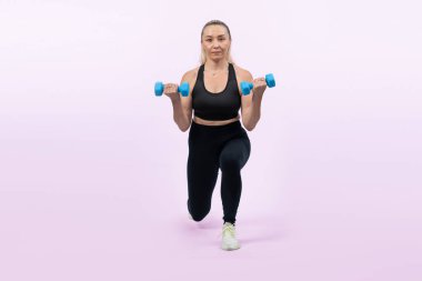 Vücut uzunluğunun tamamı aktif ve sportif yaşlı kadın halterini kaldırırken izole edilmiş arka planda ağırlık egzersizi yapıyor. Emekliler için sağlıklı aktif fizik ve vücut bakımı yaşam tarzı. Etki