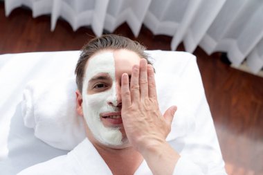 Kaplıca salonunun sakin atmosferi, insan müşterisi modern gün ışığında lüks yüz kremi masajıyla kendini yenileme zevkine kapılıyor. Yüz bakımı ve güzellik konsepti. Sessiz.